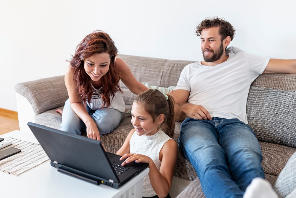 Une famille profitant de son nouveau pc portable avec le pack ZEN